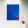 Minimalist abstract art in blue and red by Veronika Obushikhina displayed in a modern gallery with a contemporary sculpture